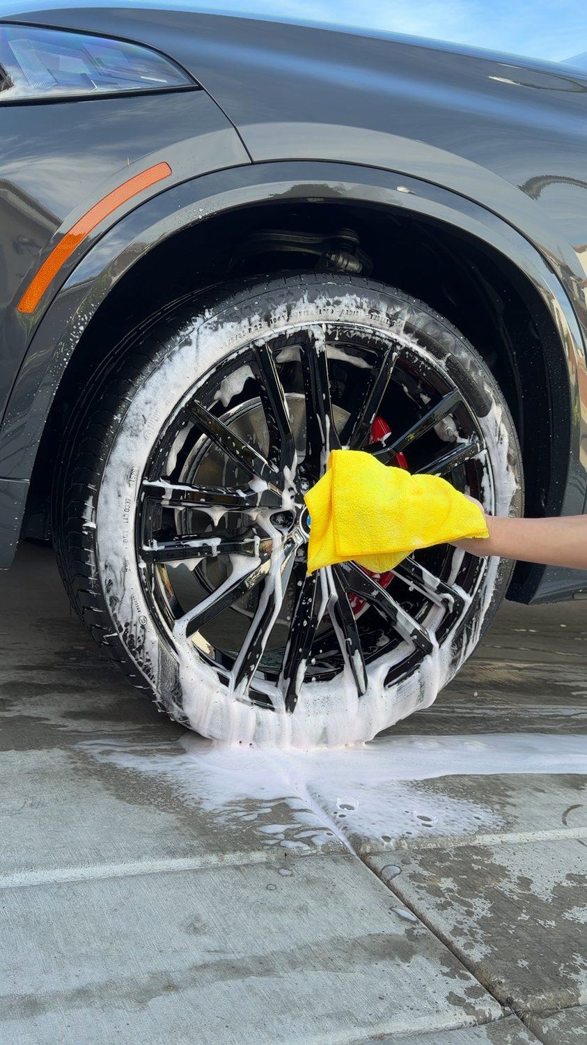 Foam being applied to a BMW wheel during a mobile detail